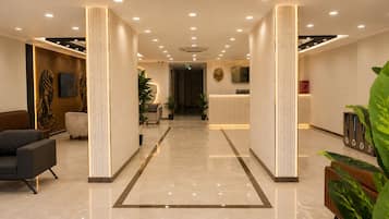 A hotel lobby with a reception desk, seating area, and a modern design.