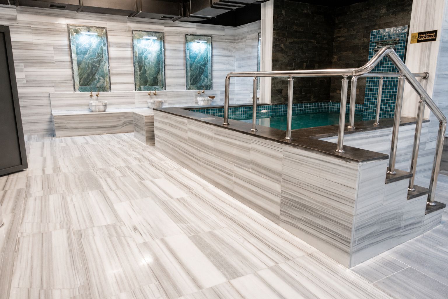 A marble-floored lobby with a reception desk, a pool area, and a sign indicating the location of the House (Hannahs) and Pool (Felicity Bath).