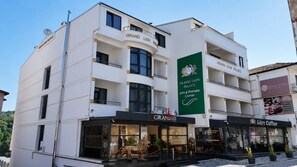 Un edificio de varios pisos con la señalización 'Grand Lion Palace' y 'Spa & Therapy Center' en la fachada.