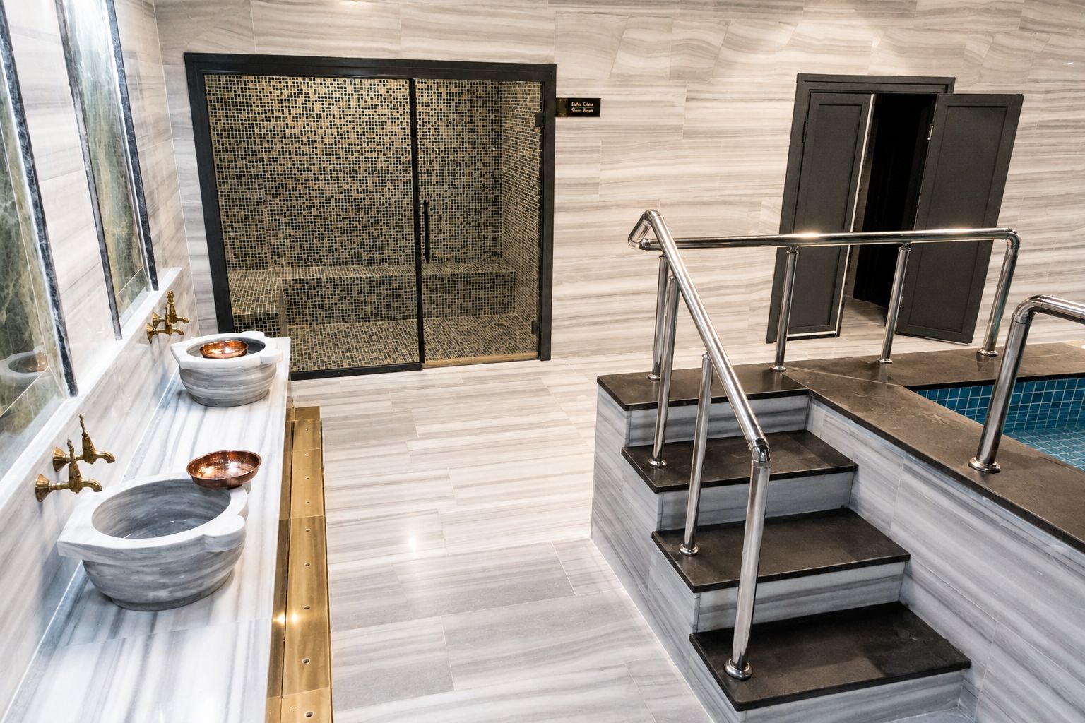 A modern bathroom with a marble floor, a freestanding bathtub, and a glass-enclosed shower area.
