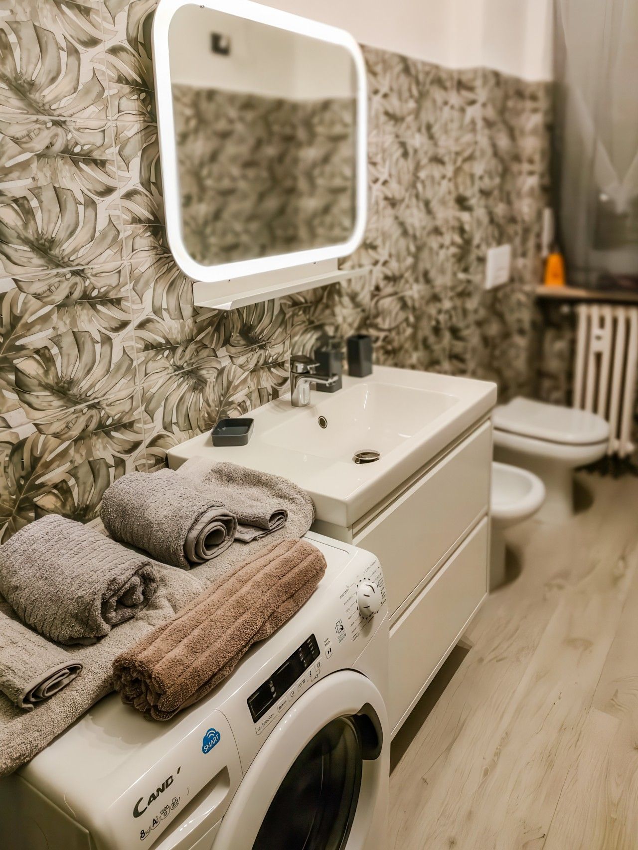 Ein Badezimmer mit Waschmaschine, Waschbecken und Toilette.