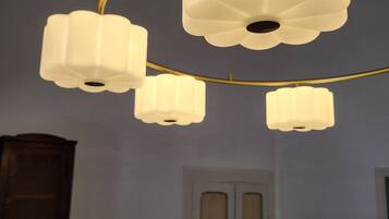 A room with a ceiling light fixture and a door with floral patterns.