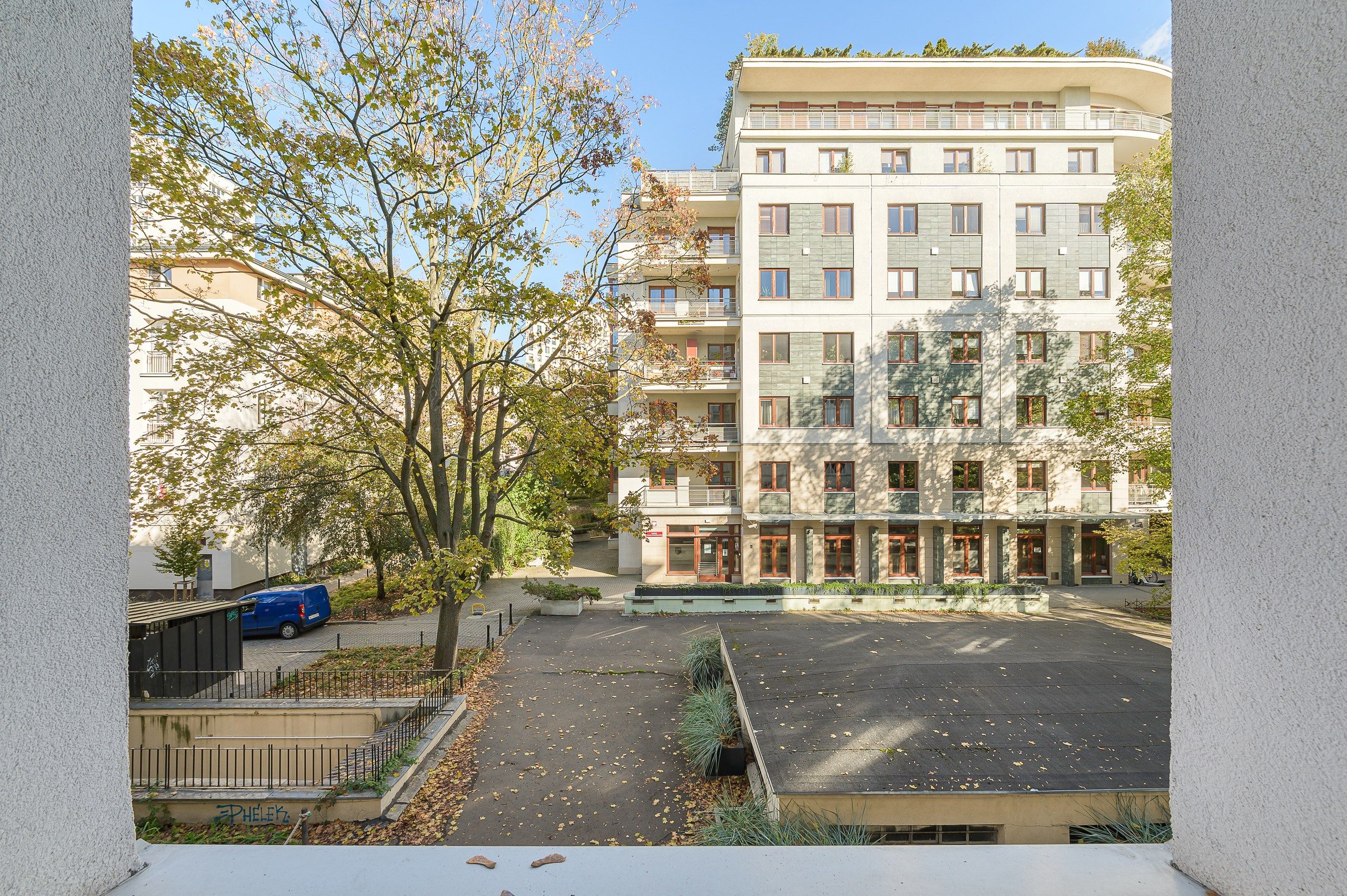 A multi-story residential building with a parking area in front.