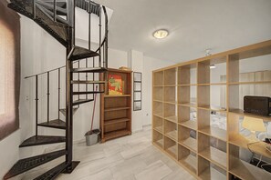 A multi-level metal staircase, a wooden bookshelf, and a desk with a lamp. - Apartment 'Macarena Seville Premium Suites' with Private Terrace and Air Conditioning (Sevilla)