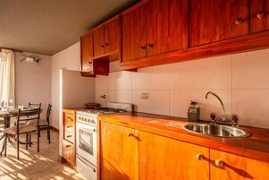 Una cocina con armarios de madera, una estufa y un lavabo.