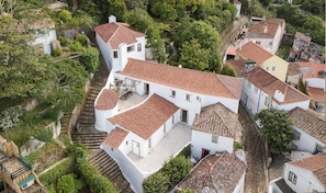 A residential area with terraced houses, steep staircases, and lush greenery.