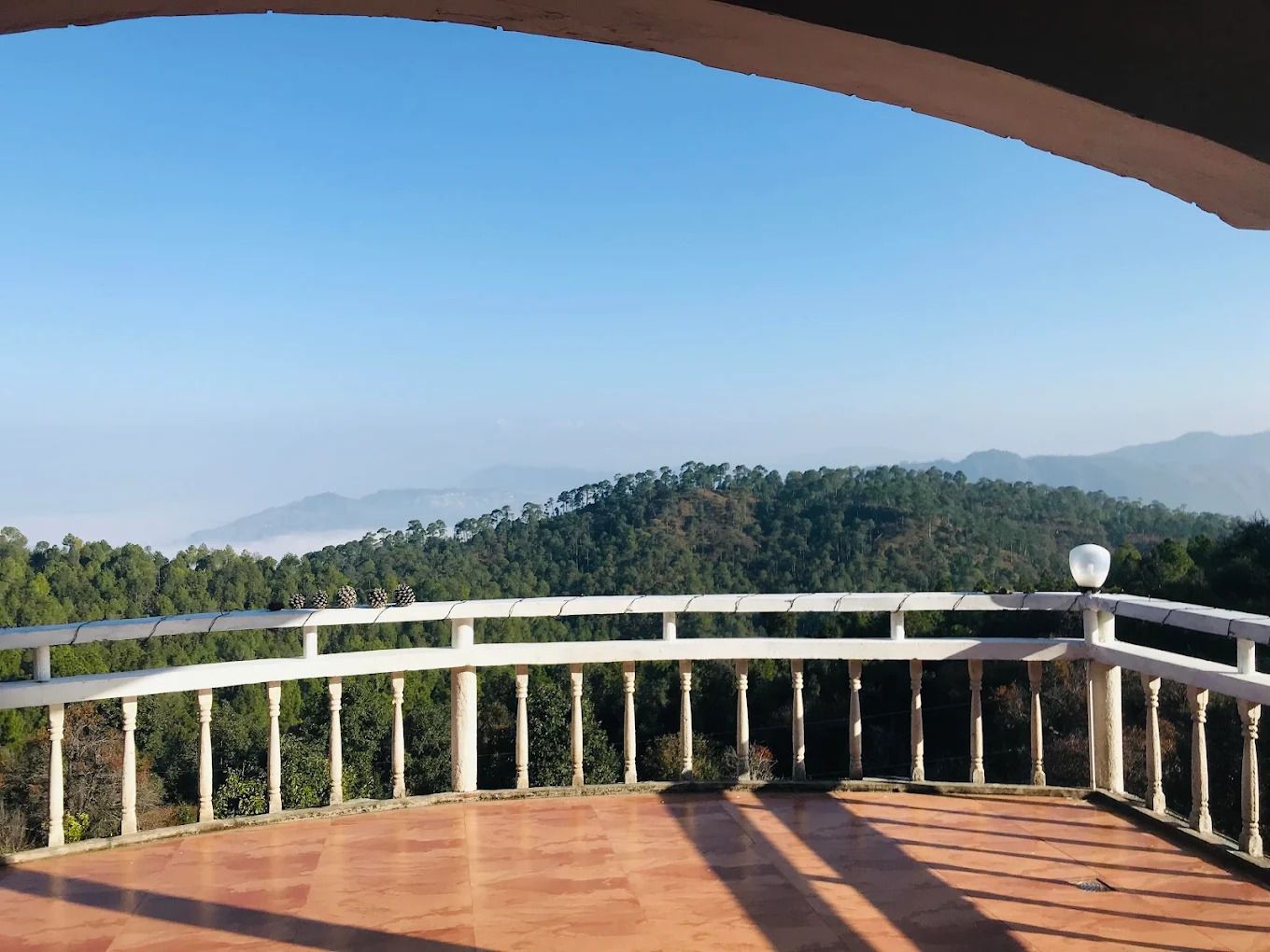Un balcón con vistas a una cadena montañosa boscosa.