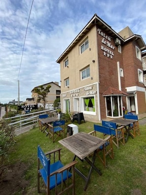 Un hotel con mesas al aire libre y un cartel que dice 'Hotel de Mar'.