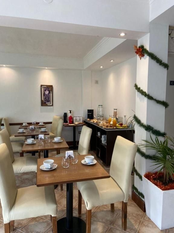 Un comedor de hotel con mesas, sillas y alimentos para el desayuno.