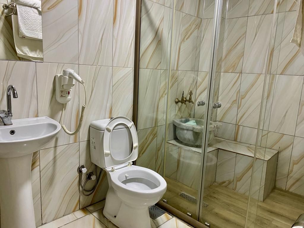 Ein Badezimmer mit Toilette, Waschbecken und Duschbereich.