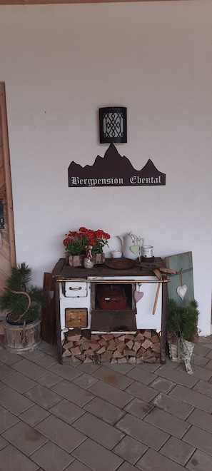 A rustic wooden cabinet with a sign above it, a small potted plant, and a wall-mounted decorative piece.