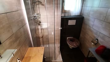 Ein Badezimmer mit Dusche, Toilette und Waschbecken.