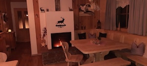 Une pièce chaleureuse avec une cheminée, des meubles en bois et une décoration murale représentant un cerf.