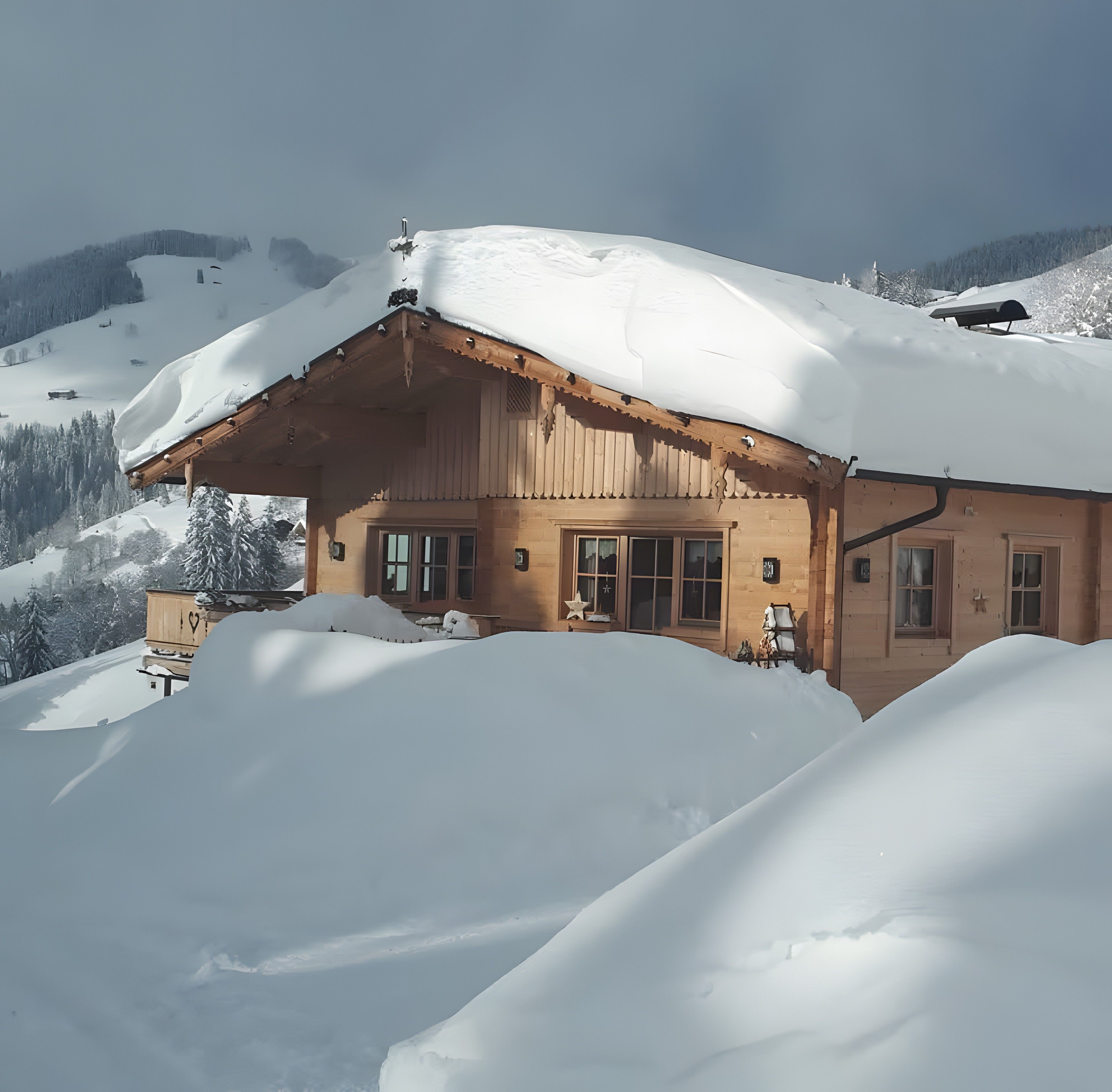 Un chalet en bois doté d’un toit en pente, entouré d’un paysage enneigé et de montagnes.