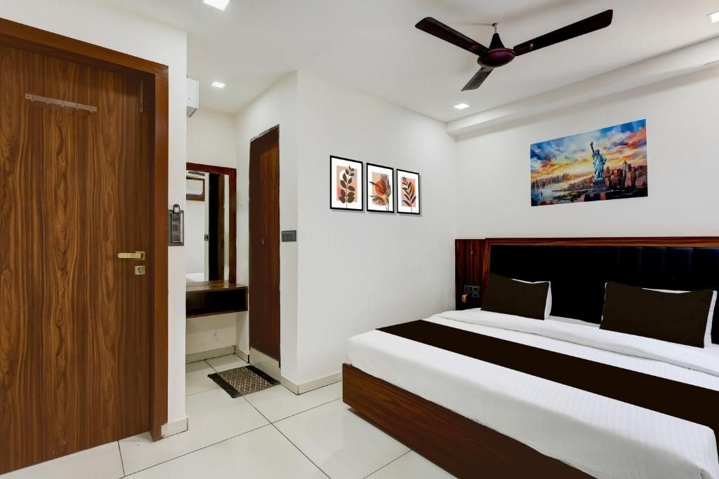 A bedroom with a bed, a ceiling fan, and wall art.