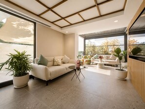 A modern living room with a sofa, coffee table, and potted plants. - Leaf Lara Hotel (Antalya)