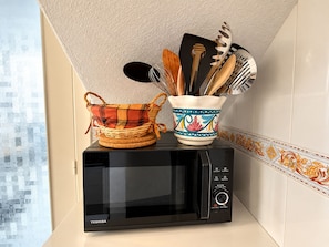 A microwave oven with a basket and a mug on top. - Upper-floor Bungalow With Private Solarium and Community Pool in San Luis (Torrevieja)