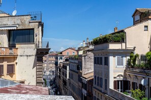 Une rue étroite bordée de bâtiments historiques, dont certains sont dotés de balcons et d’antennes paraboliques.