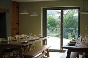 A dining area with a large table set for a meal, chairs, and benches. - Large modern farmhouse, surrounded by 40 acres of private countryside (Unknown)