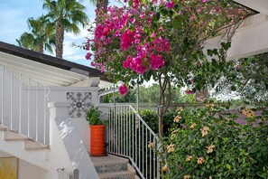 Eine Treppe mit Geländer, einem Blumentopf und einer Wand mit dekorativem Fliesendesign.