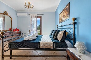 Ein Schlafzimmer mit einem Bett, einem Schminktisch, einem Spiegel, einer Chandelier und einem Gemälde an der Wand.