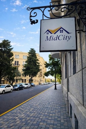 A street sign with the text 'MidCity' and a graphic of a house. - Midcity Hotel (Baku)