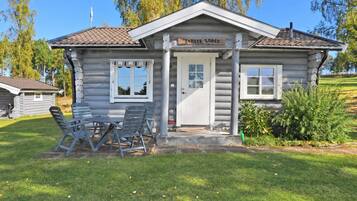 A log cabin with a front porch, two windows, and a sign that reads 'Badger Lodge.'