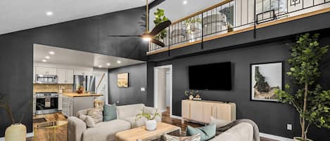 A modern living room with a sofa, coffee table, and a TV mounted on the wall.