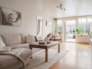A modern living room with a sofa, coffee table, and a view of the outdoors. - 6 Person Holiday Home in Tyresjo (Tyreso)
