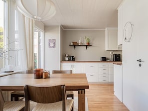 A kitchen with white cabinets, a wooden countertop, and a coffee machine. - 6 Person Holiday Home in Tyresjo (Tyreso)