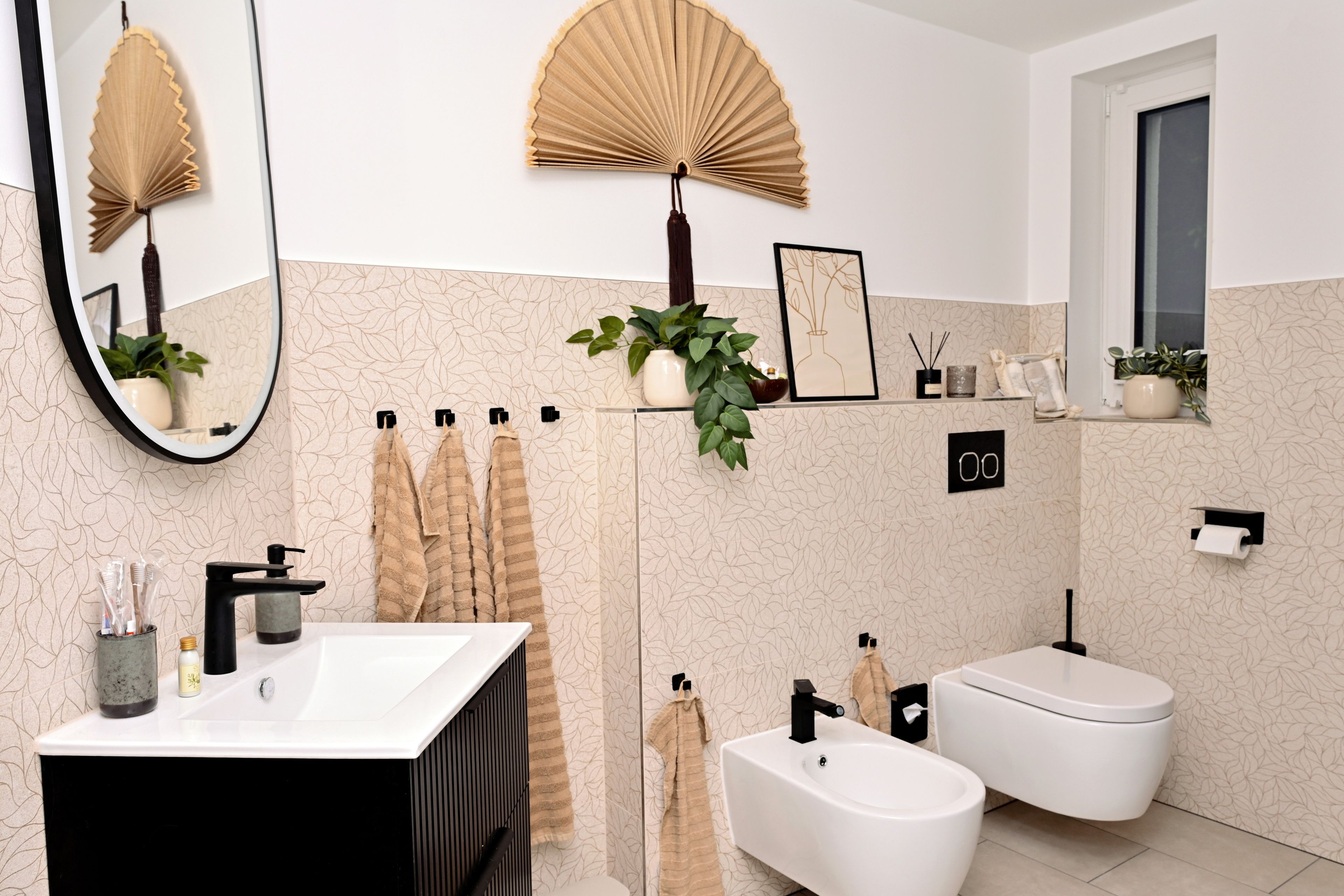 Ein modernes Badezimmer mit einem großen Spiegel, einem weißen Waschbecken, einer schwarzen Waschtischunterschrank und einer Dusche.