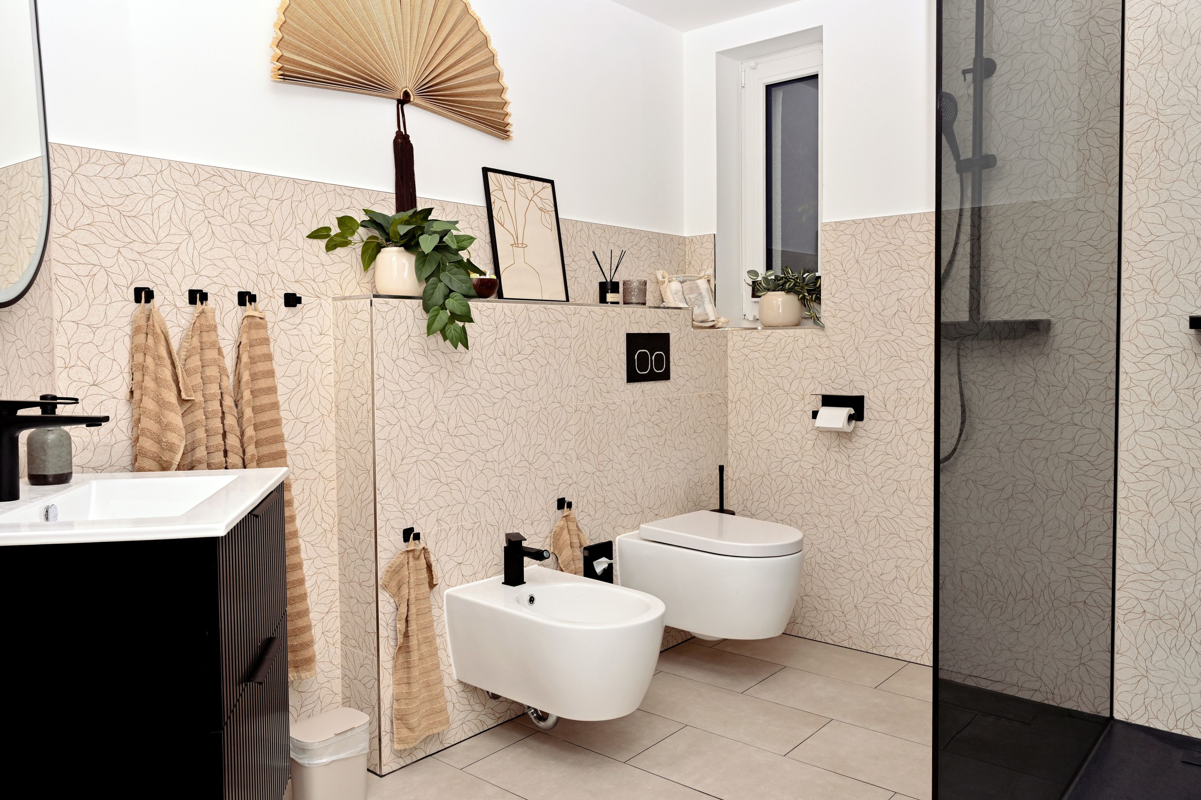 Une salle de bain moderne équipée de toilettes, d’un bidet, d’un lavabo et d’une zone douche.