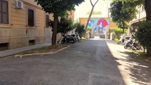 A narrow street with parked motorcycles and trees lining the sides. - Bright and spacious apartment in Rome's Ostiense and Gazometro neighborhoods (Roma)