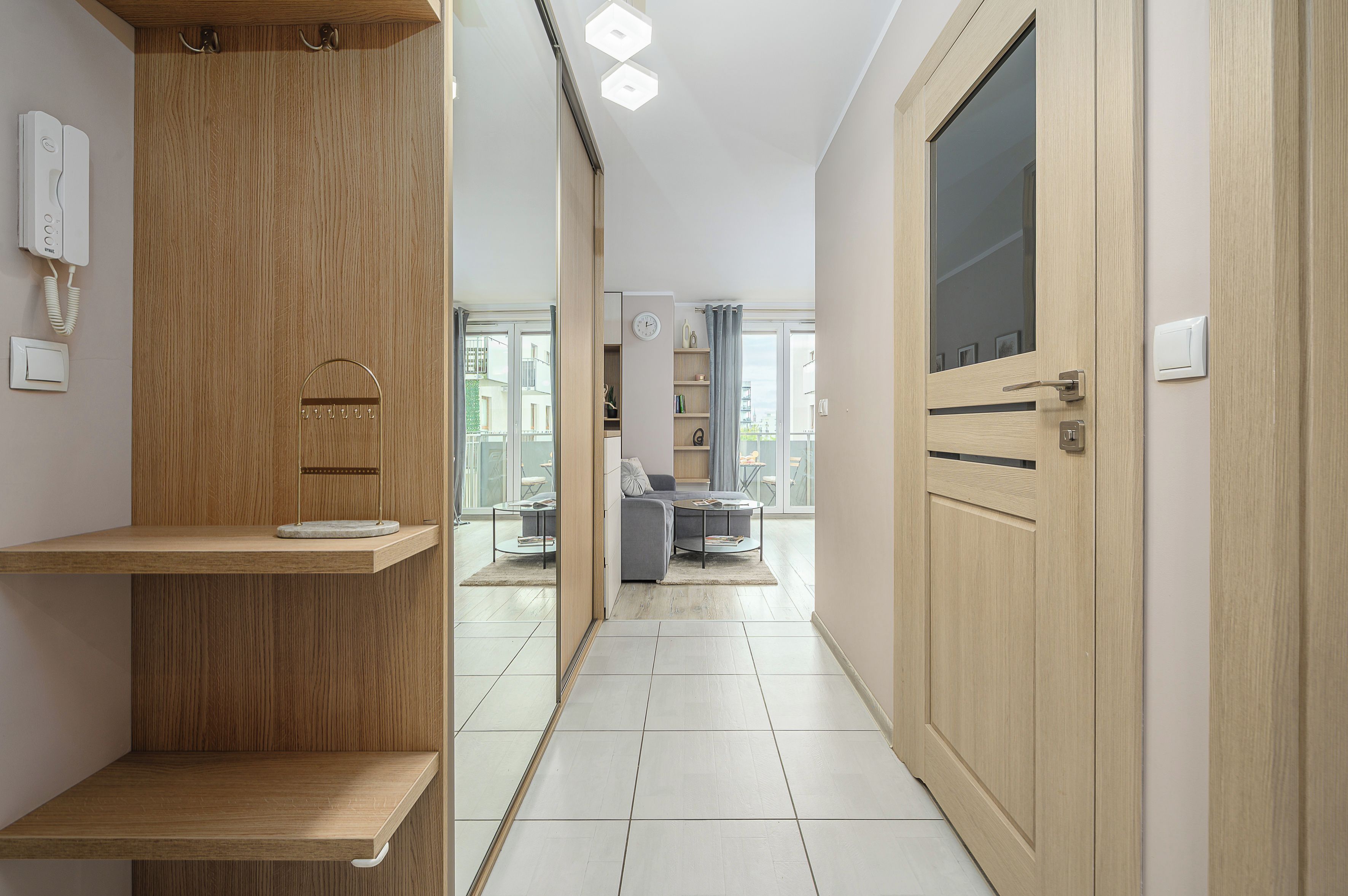 Un interior moderno con un mueble de madera, una puerta con ventana y vistas a un balcón.
