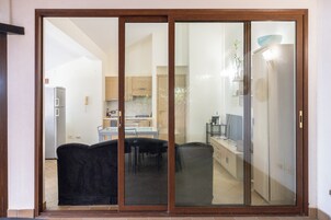 Uma porta de vidro deslizante dá acesso a uma cozinha com área de jantar.