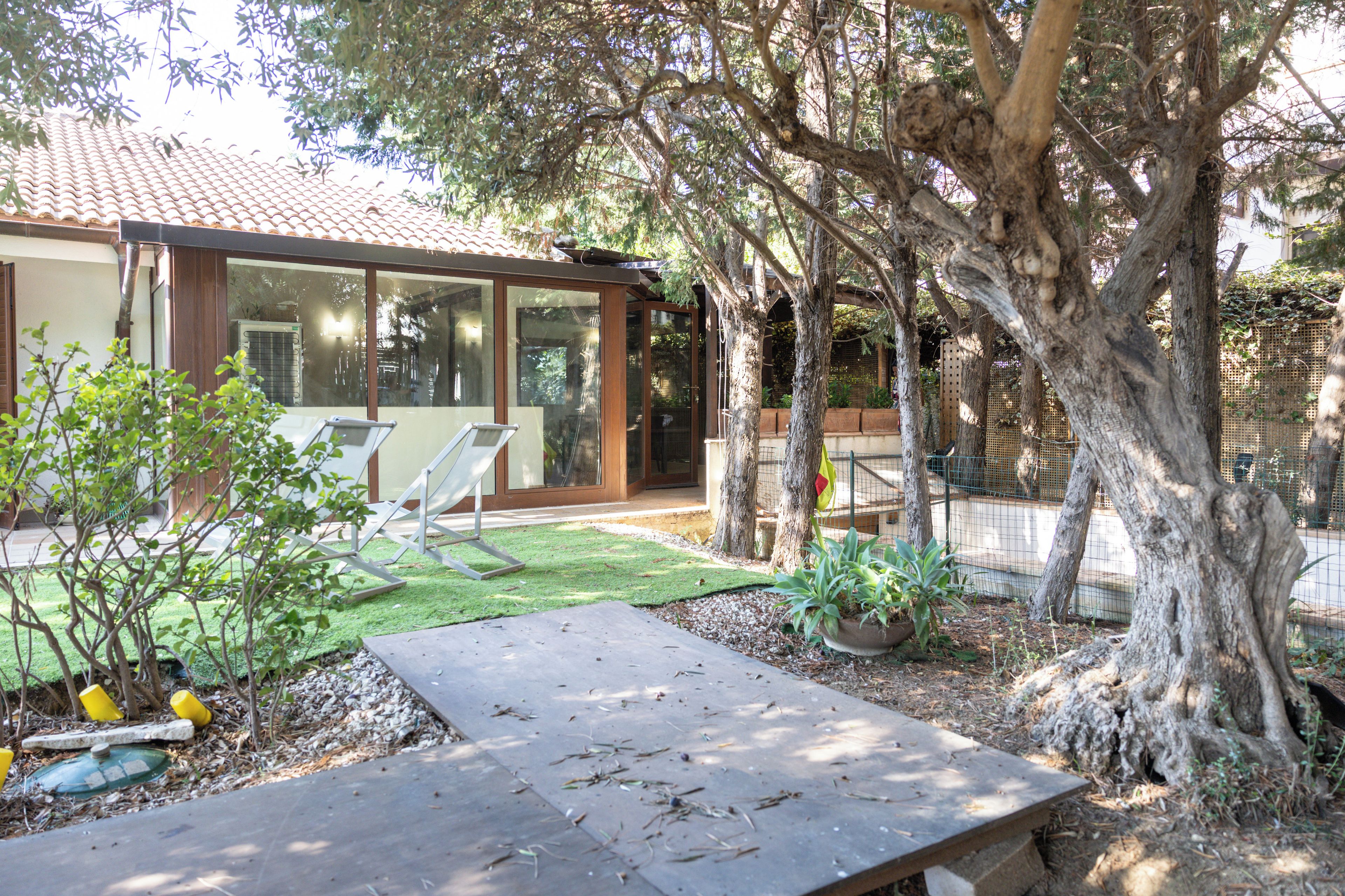 Propiedad residencial con un patio, césped y un árbol grande.
