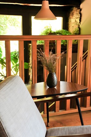 A wooden bench with a vase of flowers, a table, and a lamp. - Holiday Home 'Casa Yañez Duplex' with Mountain View, Shared Garden and Wi-Fi (Chantada)