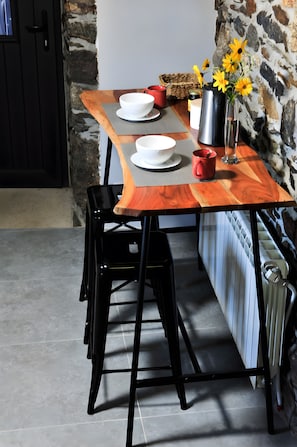 A dining table with two white bowls, a red mug, and a vase with yellow flowers. - Holiday Home 'Casa Yañez Duplex' with Mountain View, Shared Garden and Wi-Fi (Chantada)