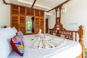 A hotel room with a bed, wooden headboard, and a large window. - 2bedroom apartment in Diani Beach with AC, Internet, private access to the beach (Diani Beach)