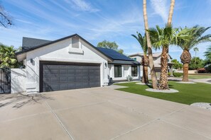 A residential property with a garage, a solar panel roof, and a well-maintained lawn with palm trees. - 3 Bedroom/ Private Fenced Backyard /Desert Style (Gilbert)
