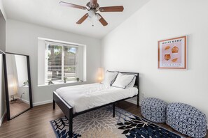 A bedroom with a bed, a ceiling fan, a window with blinds, a wall-mounted light, and a framed picture. - 3 Bedroom/ Private Fenced Backyard /Desert Style (Gilbert)