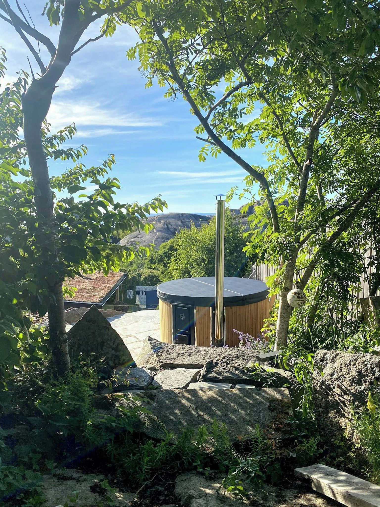 Uma banheira de hidromassagem em um ambiente natural, com árvores e vista para a paisagem.