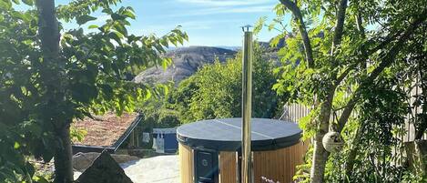 Uma banheira de hidromassagem em um ambiente natural, com árvores e vista para a paisagem.