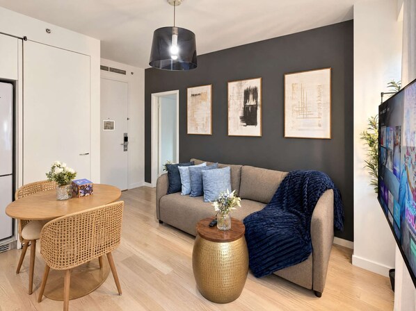 Una sala de estar moderna con un sofá, una mesa de centro y un comedor con mesa y sillas.