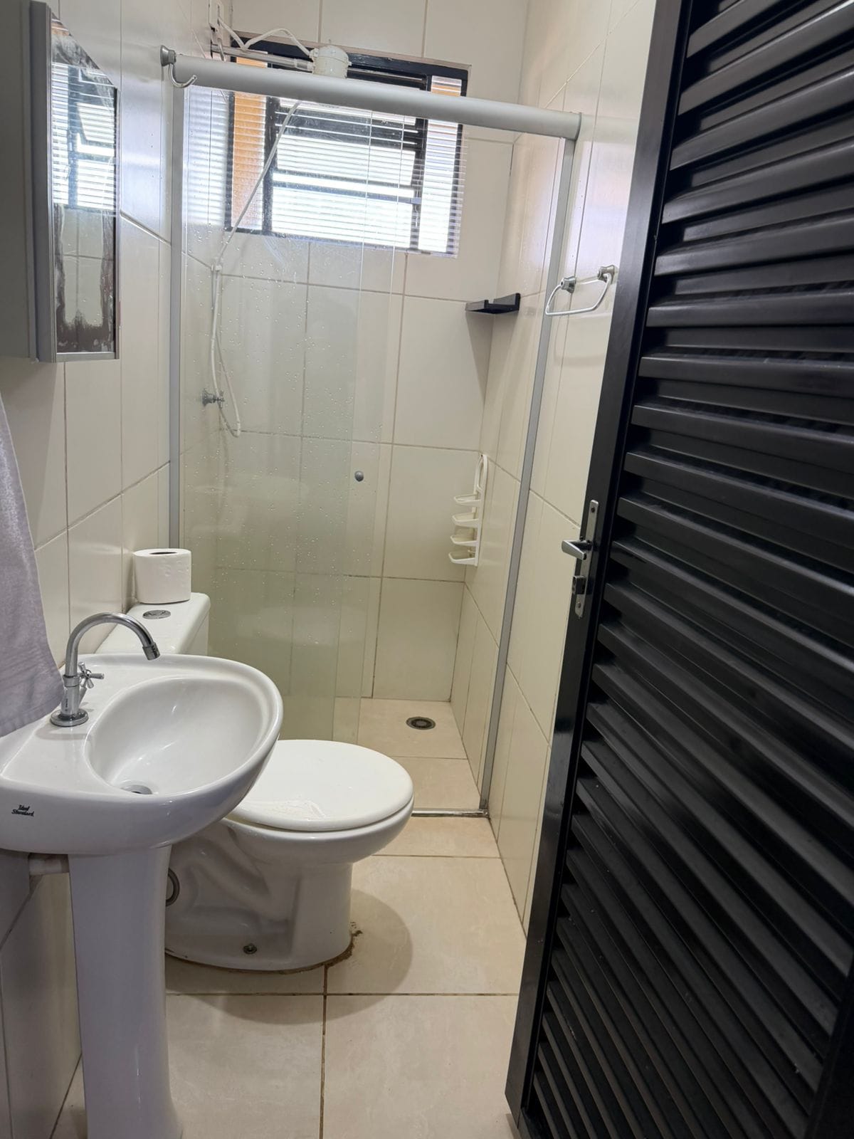 A bathroom with a toilet, sink, and glass-enclosed shower.