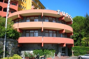 Un edificio de varios pisos con fachada curva, balcones y un cartel que dice 'EUROPE'.