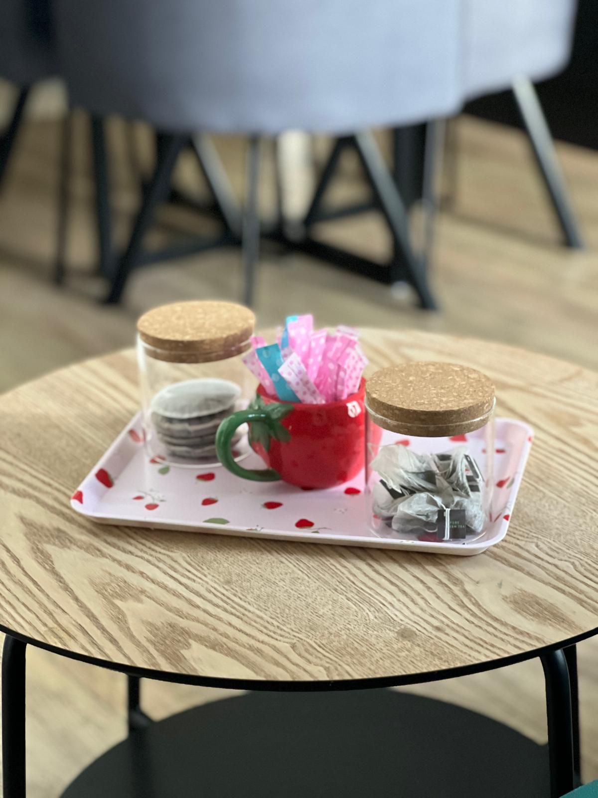 A tray with jars and a mug on a round table.