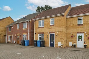A row of terraced houses with brick facades, numbered doors, and a cobblestone street. - Dudley Gardens 3 Bedroom 1 Bath Hse (Poole)