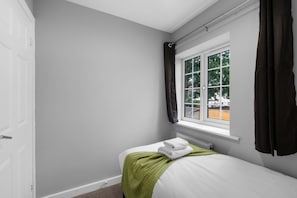 A small, single-bed room with a window, a radiator, and a door. - Dudley Gardens 3 Bedroom 1 Bath Hse (Poole)