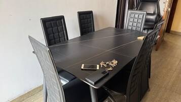 A conference table with four chairs, a smartphone, and a set of keys on the table.